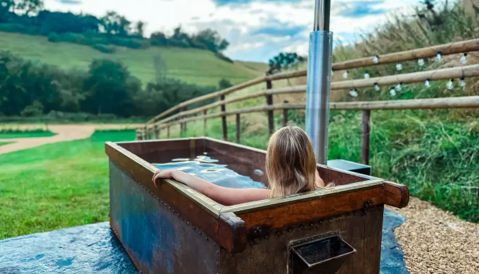 Copper wood-fired hot tub outside Horsecombe Lodge in Somerset countryside