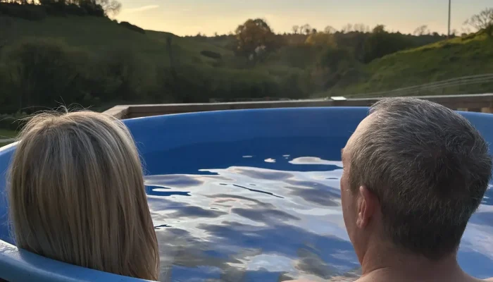Wood-fired hot tub outside safari lodge in Somerset countryside at Sunset